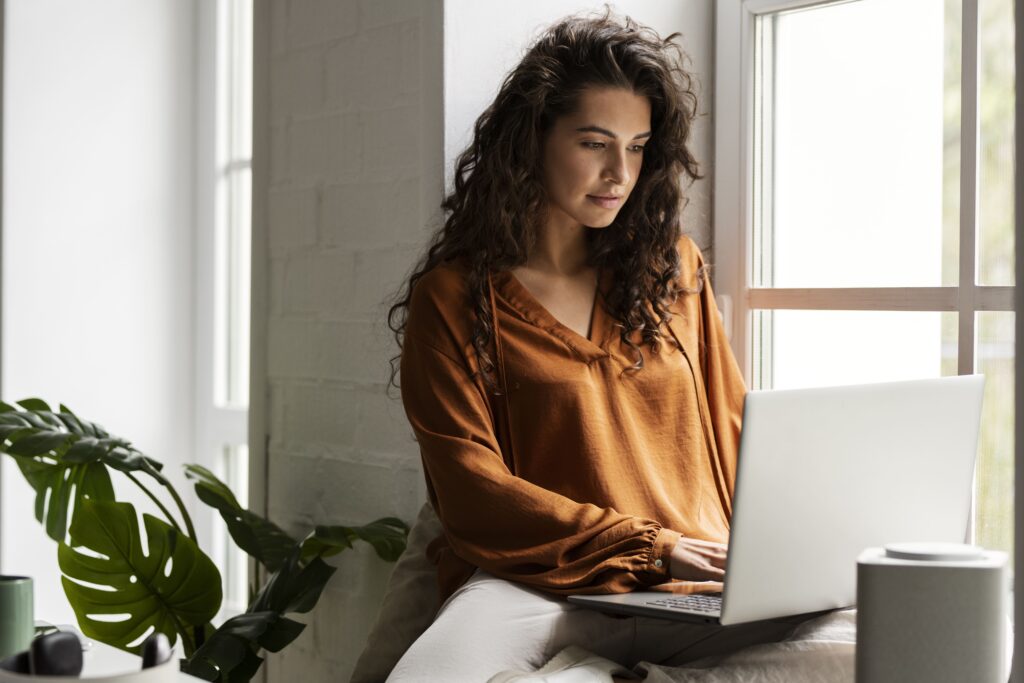 Imagem de uma mulher digitando no notebook para ilustrar artigo sobre agência de textos. Foto: Freepik