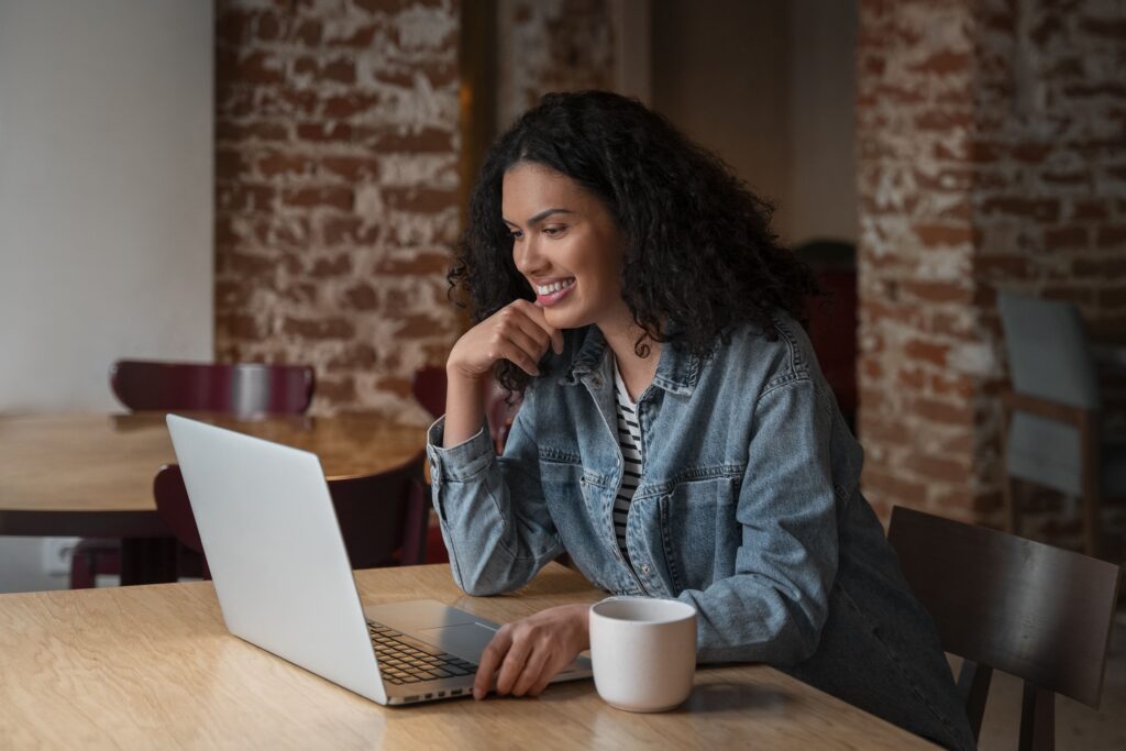 Imagem de uma mulher de perfil, utilizando o notebook para ilustrar artigo sobre conteúdo otimizado para SEO. Foto: Freepik