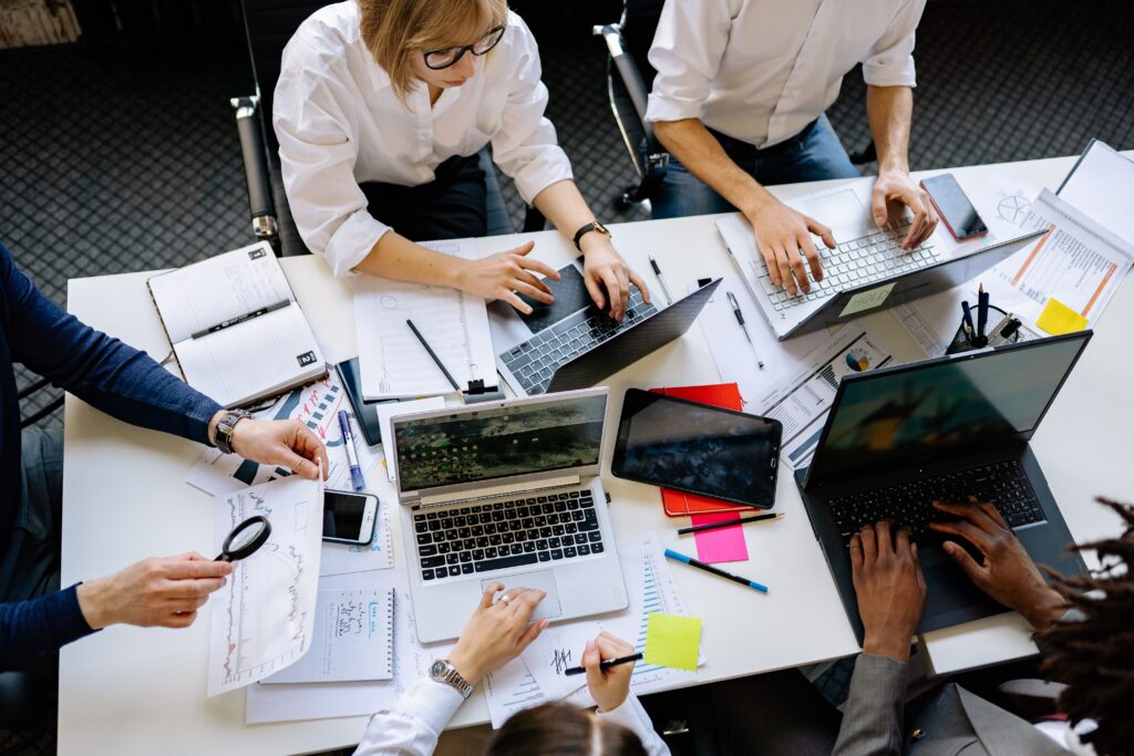 Imagem de um grupo trabalhando em torno de uma mesa e discutindo SEO para IA. Imagem: Pexels.